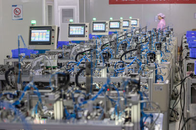 8月14日,在贛州訊康電子科技,工作人員從T1-T2全自動(dòng)穿環(huán)機(jī)旁走過(guò),該機(jī)器生產(chǎn)磁性元器件。新華社記者 才揚(yáng) 攝